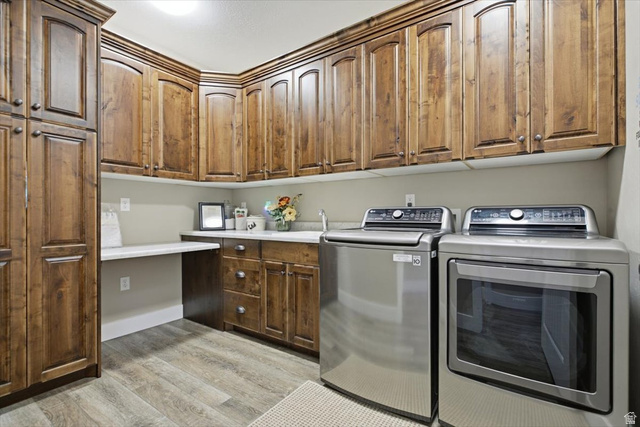 3123 East Riverdale Road Preston, ID 83263 - Photo 16 of 52 Utility room featuring extensive wood cabinetry, wood-finish flooring, a built-in countertop, and a utility sink