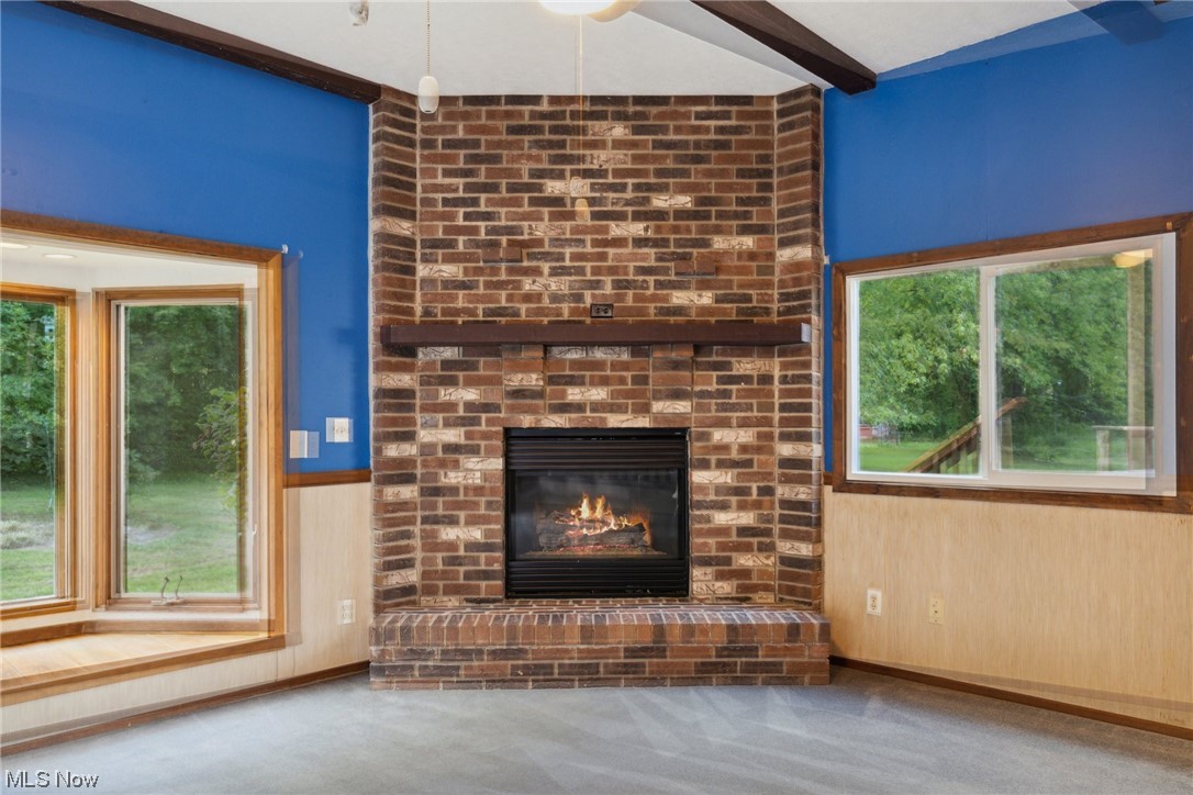 2715 Douglas Road Ashtabula, OH 44004 - Photo 13 of 34 Carpeted living room featuring a fireplace and brick wall