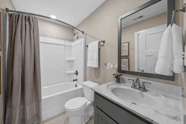 a bathroom with a sink a toilet and a large mirror