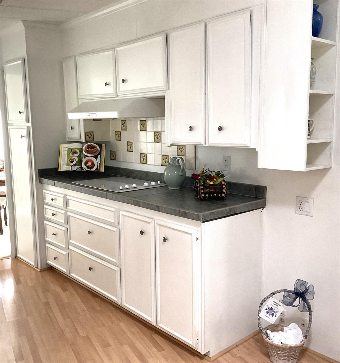 10124 Hidden Springs Drive Grass Valley, CA 95949 - Photo 18 of 27 a kitchen with granite countertop white cabinets and white appliances