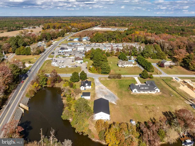 an aerial view of ocean and residential houses with outdoor space