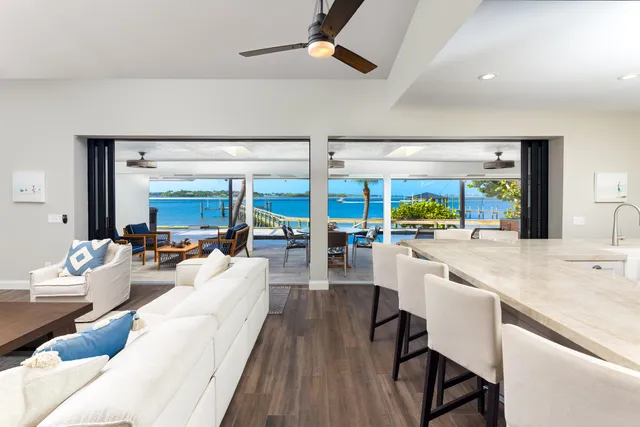 a view of a kitchen with kitchen island stainless steel appliances a large window and furniture