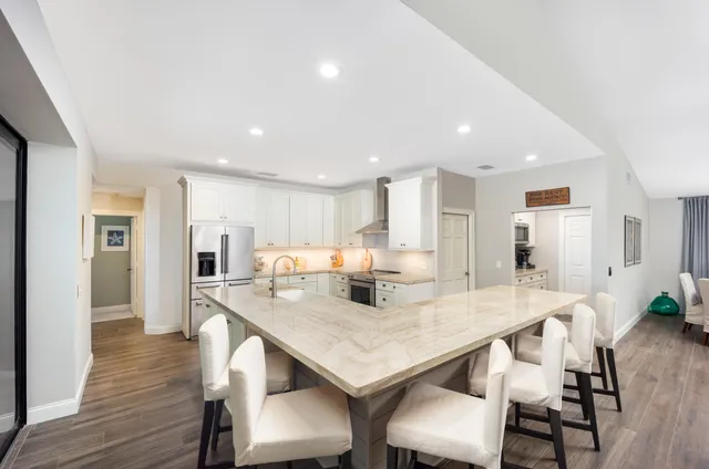 a kitchen with a dining table chairs and wooden floor
