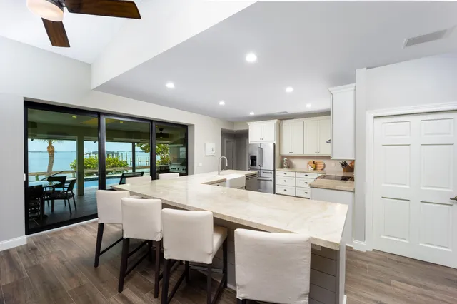 a kitchen with kitchen island a dining table chairs and wooden floor