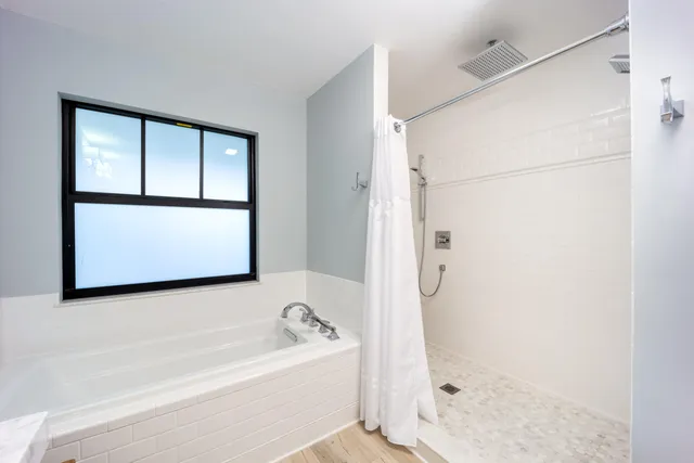 a bathroom with a bathtub and a shower