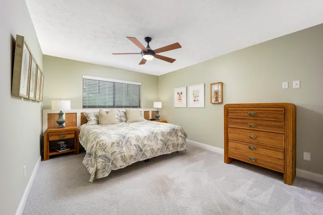 a spacious bedroom with a bed and a ceiling fan