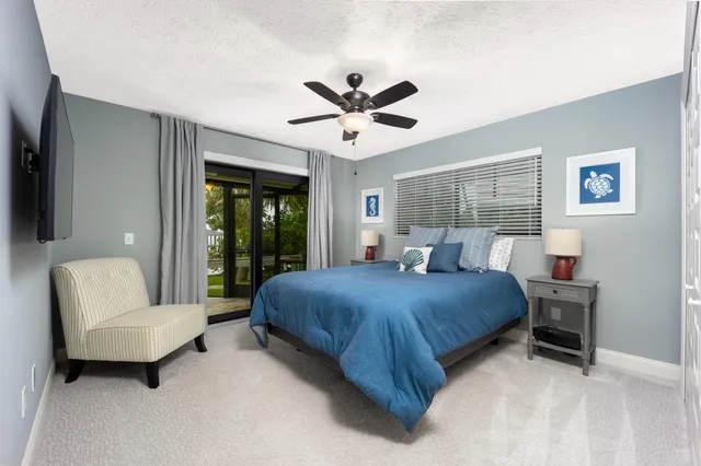 a bedroom with a bed a couch and a large window