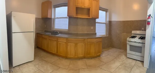 a kitchen with stainless steel appliances granite countertop a refrigerator and a stove