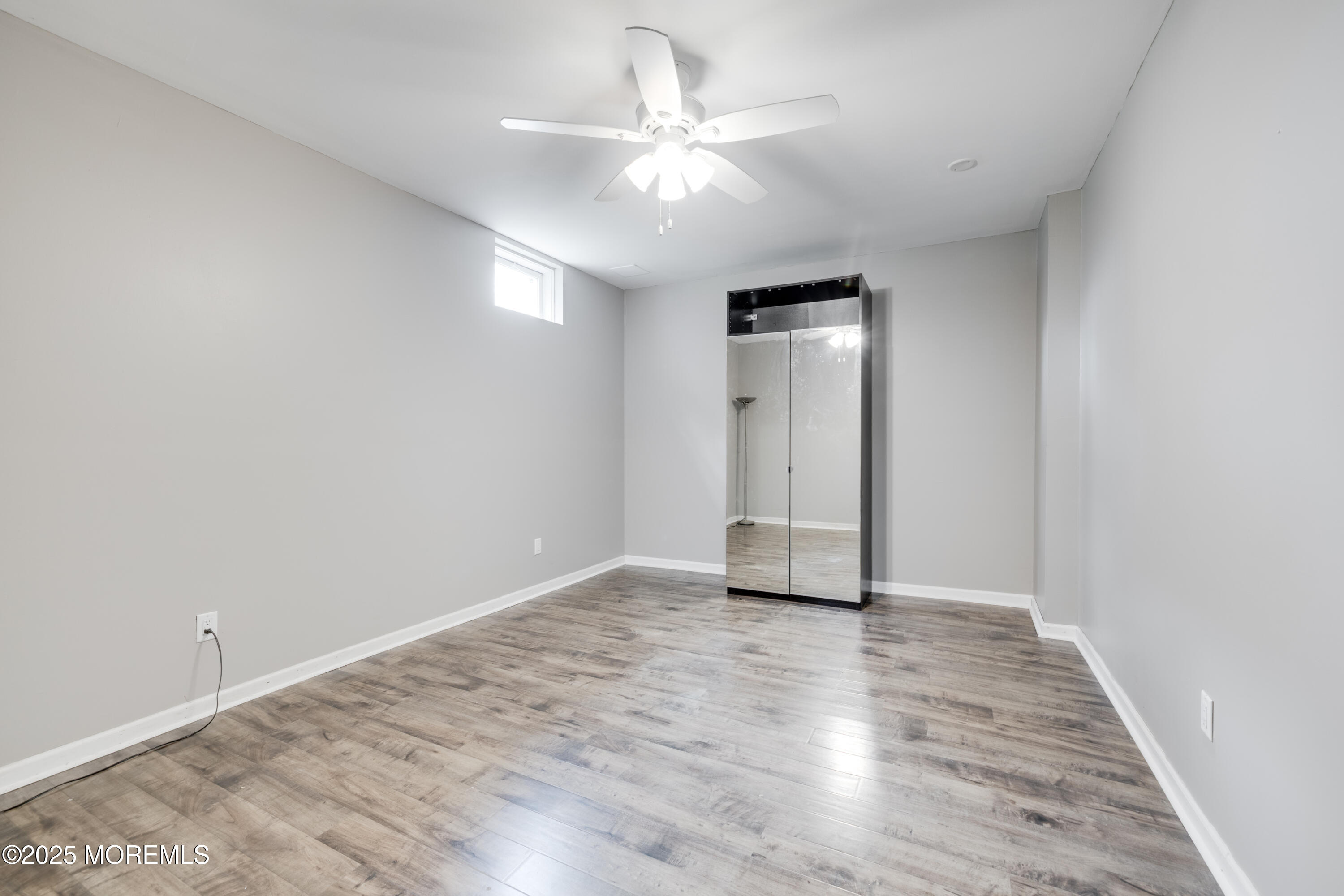 501 Newtons Corner Road Howell, NJ 07731 - Photo 27 of 29 an empty room with wooden floor and a ceiling fan