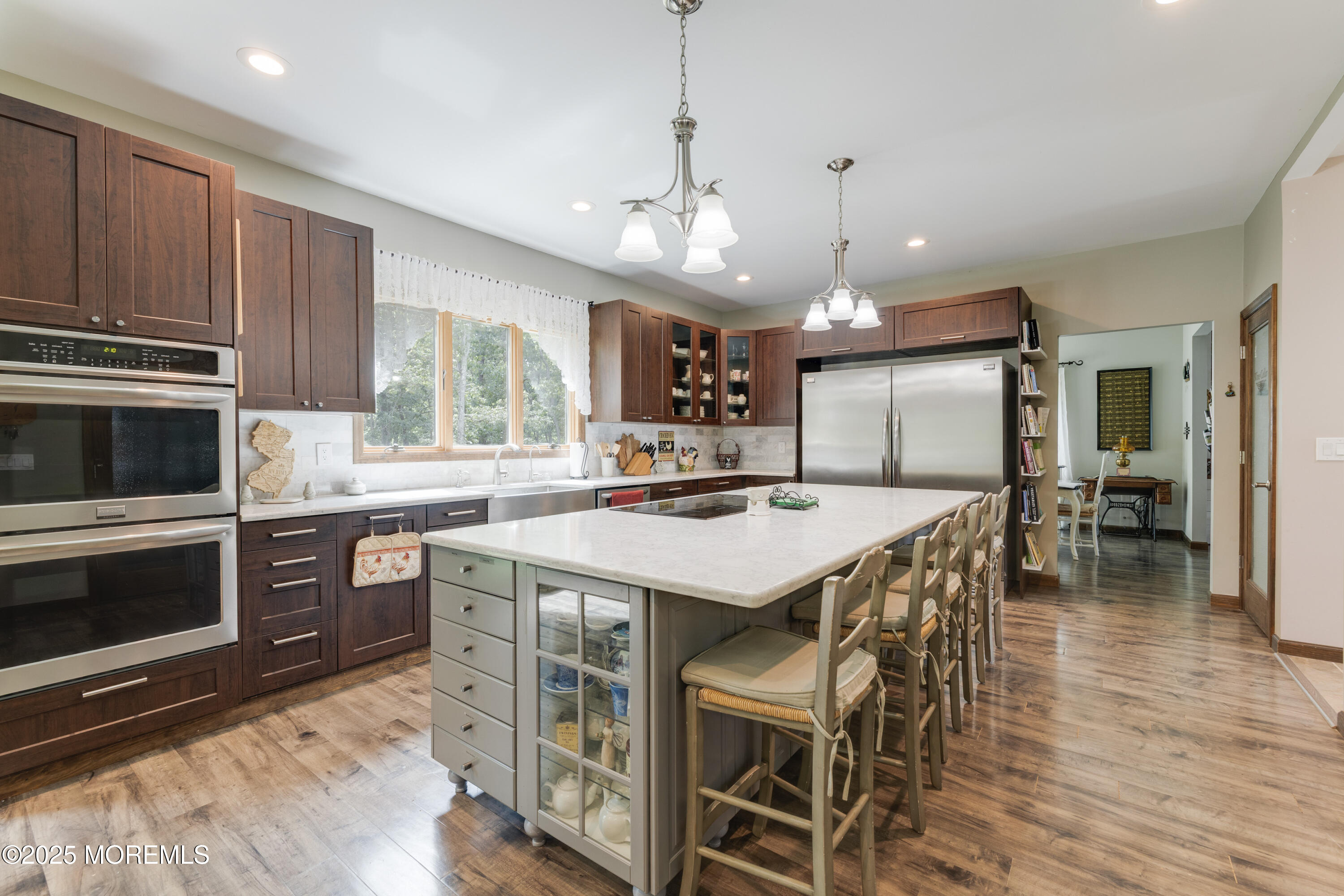 501 Newtons Corner Road Howell, NJ 07731 - Photo 3 of 29 a kitchen with stainless steel appliances granite countertop a stove top oven a refrigerator a sink and a dining table with wooden floor