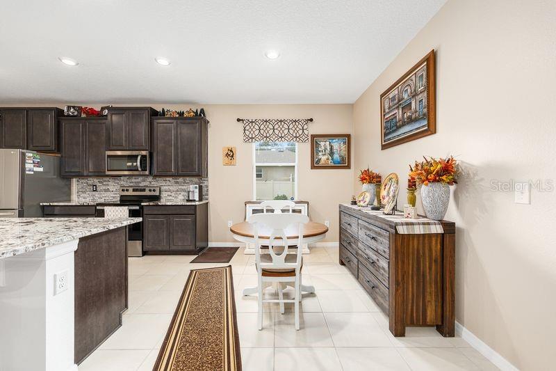 5077 Northeast 16th Street Ocala, FL 34470 - Photo 13 of 47 a kitchen with stainless steel appliances kitchen island granite countertop a stove a sink and a refrigerator