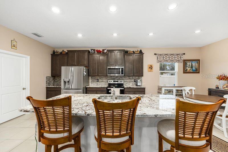 5077 Northeast 16th Street Ocala, FL 34470 - Photo 14 of 47 a dining room with furniture a rug and a chandelier