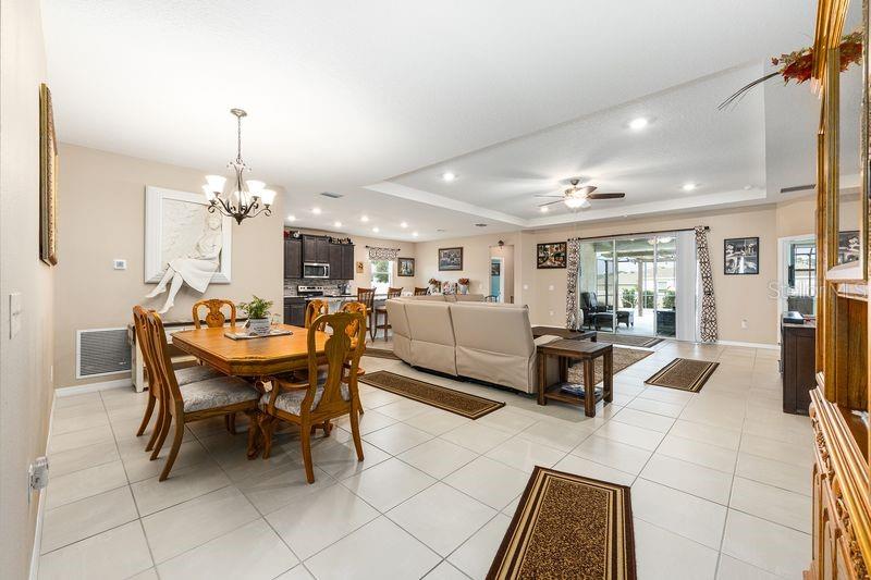 5077 Northeast 16th Street Ocala, FL 34470 - Photo 19 of 47 a living room with furniture a dining table and a chandelier