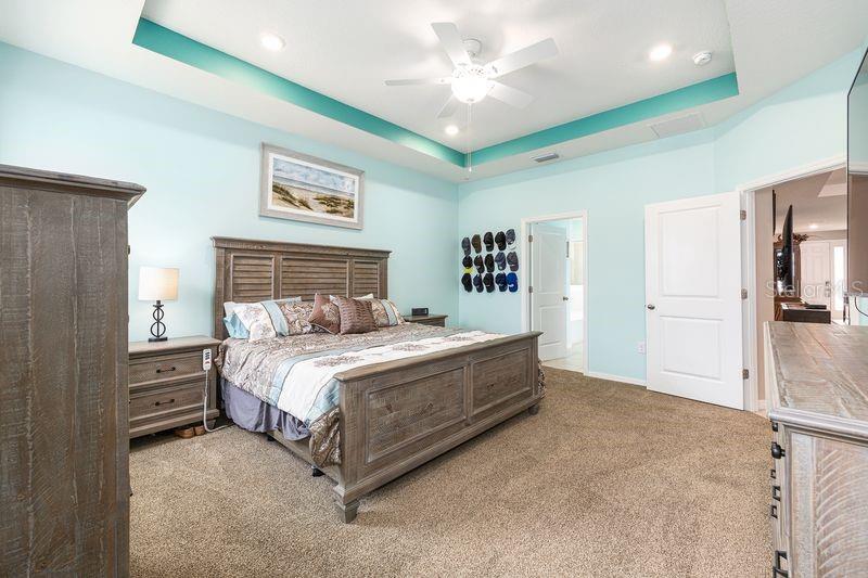 5077 Northeast 16th Street Ocala, FL 34470 - Photo 21 of 47 a spacious bedroom with a bed and a chandelier