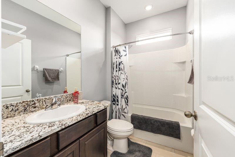 5077 Northeast 16th Street Ocala, FL 34470 - Photo 32 of 47 a bathroom with a granite countertop sink toilet and shower