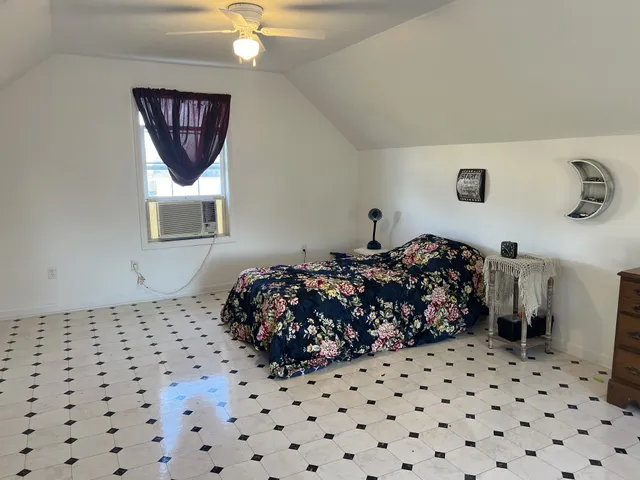 a bedroom with a bed and a painting on the wall