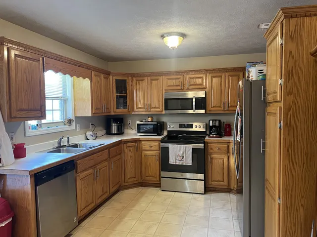a kitchen with stainless steel appliances granite countertop a refrigerator and a stove top oven