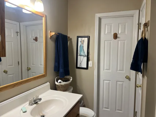 a bathroom with a sink and mirror with toilet