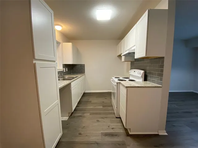 a kitchen with granite countertop white cabinets and white appliances