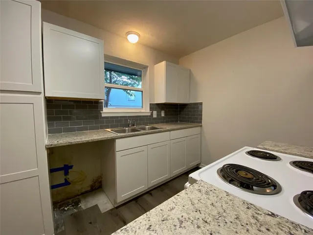 a kitchen with a sink a stove and cabinets