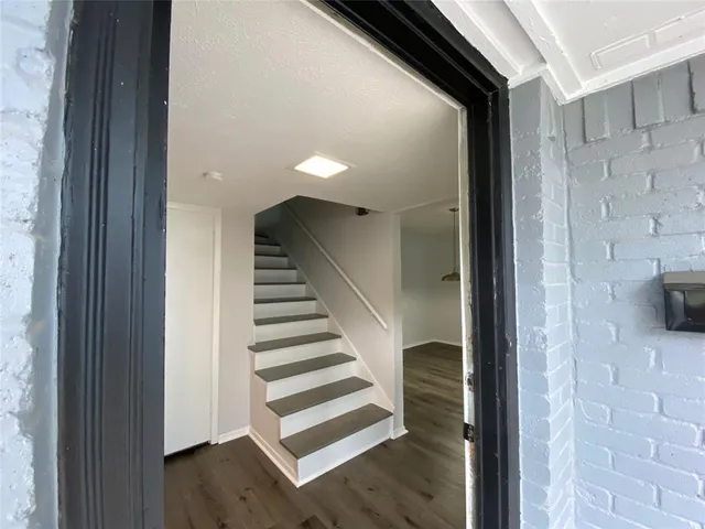 a view of entryway and hall with wooden floor