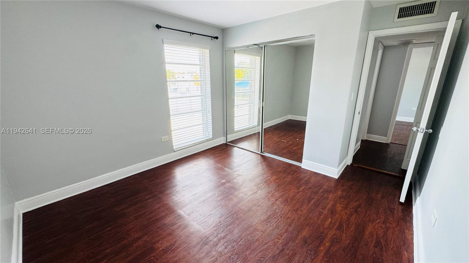 7226 Southwest 94th Place, Unit F7 Miami, FL 33173 - Photo 3 of 17 an empty room with wooden floor and window