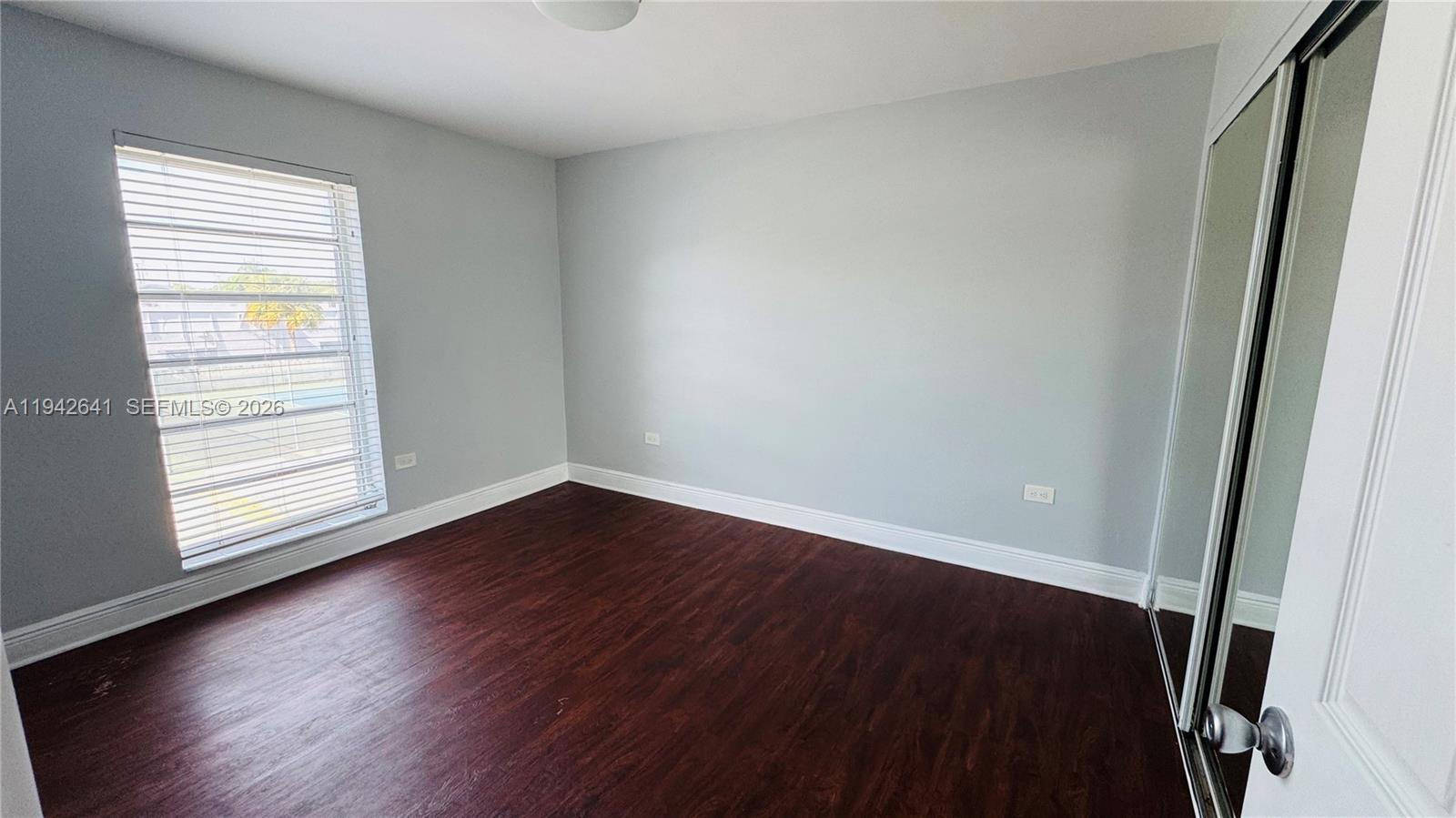 7226 Southwest 94th Place, Unit F7 Miami, FL 33173 - Photo 4 of 17 an empty room with wooden floor and windows