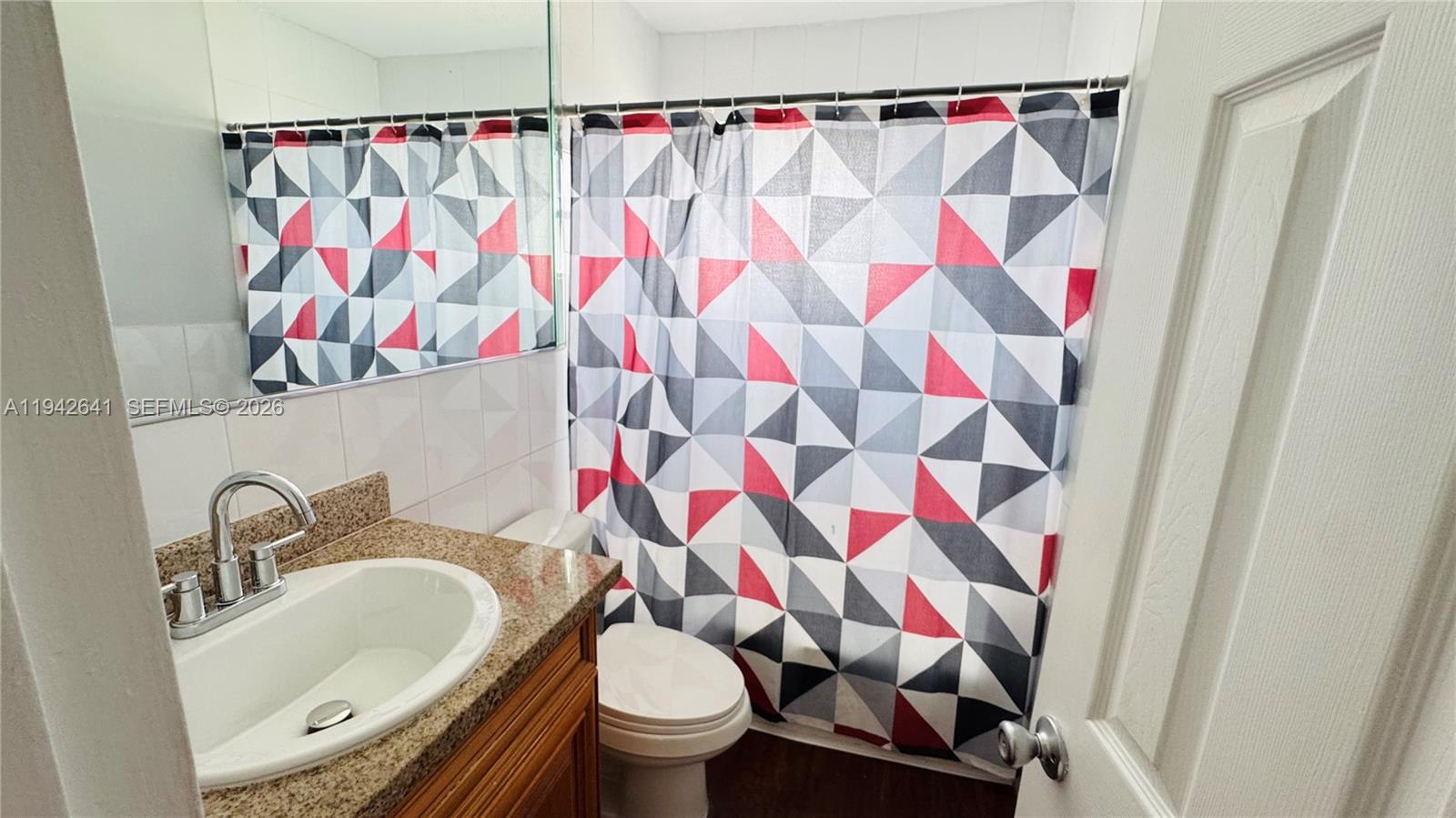 7226 Southwest 94th Place, Unit F7 Miami, FL 33173 - Photo 6 of 17 a bathroom with a sink toilet and shower curtain
