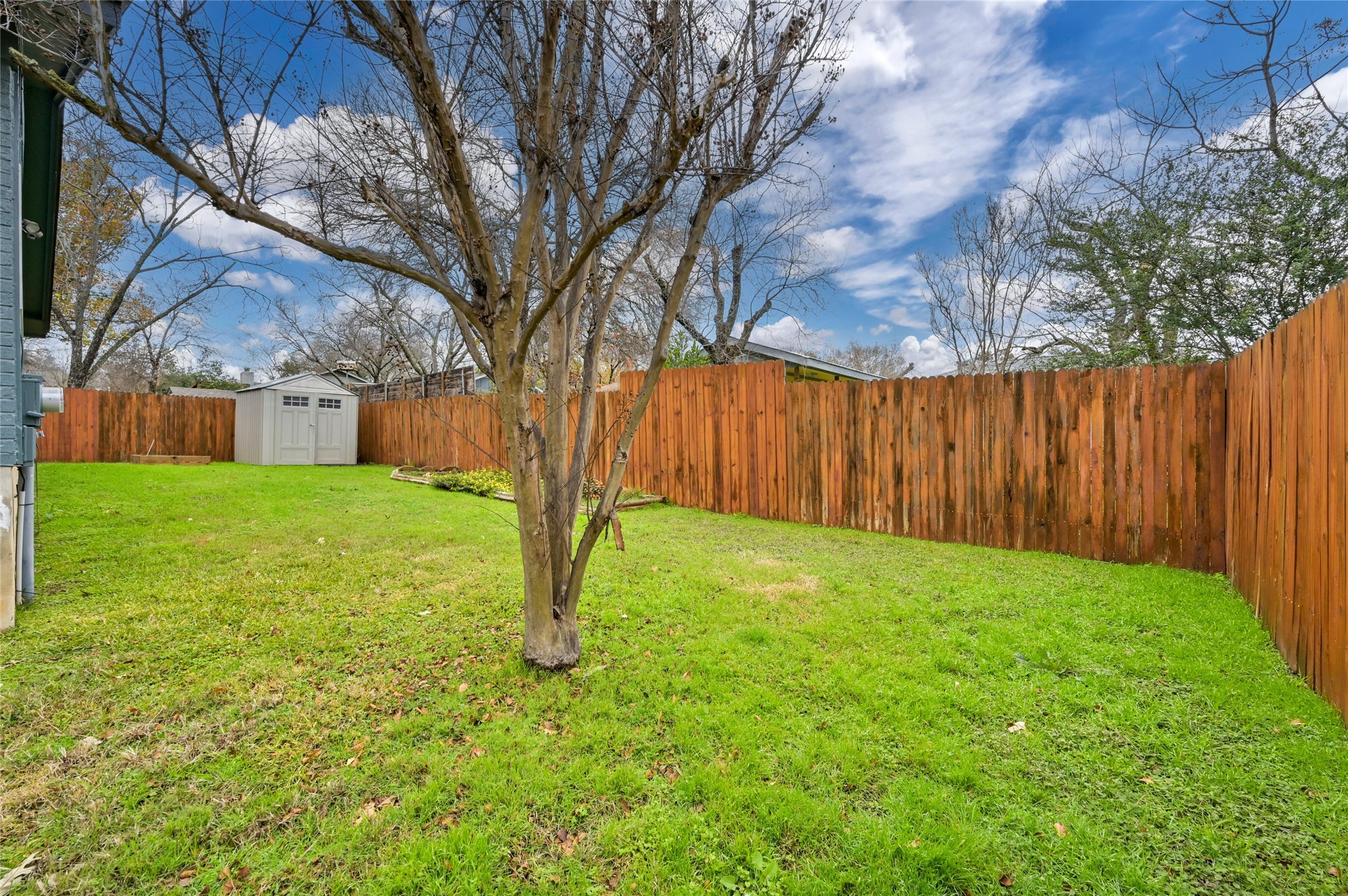 4808 Wind River Road Austin, TX 78759 - Photo 21 of 21 A spacious green lawn sits enclosed by a tall wooden privacy fence.