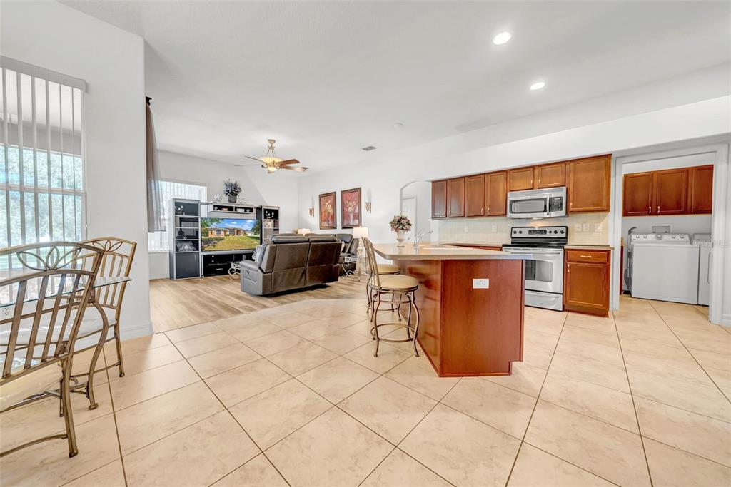 10177 Deer Street Spring Hill, FL 34608 - Photo 18 of 73 a kitchen with stainless steel appliances granite countertop a stove top oven a dining table and chairs