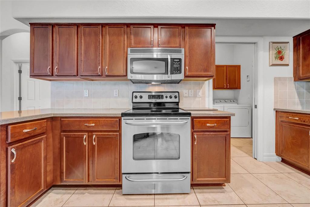 10177 Deer Street Spring Hill, FL 34608 - Photo 24 of 73 a kitchen with stainless steel appliances granite countertop a stove and a microwave