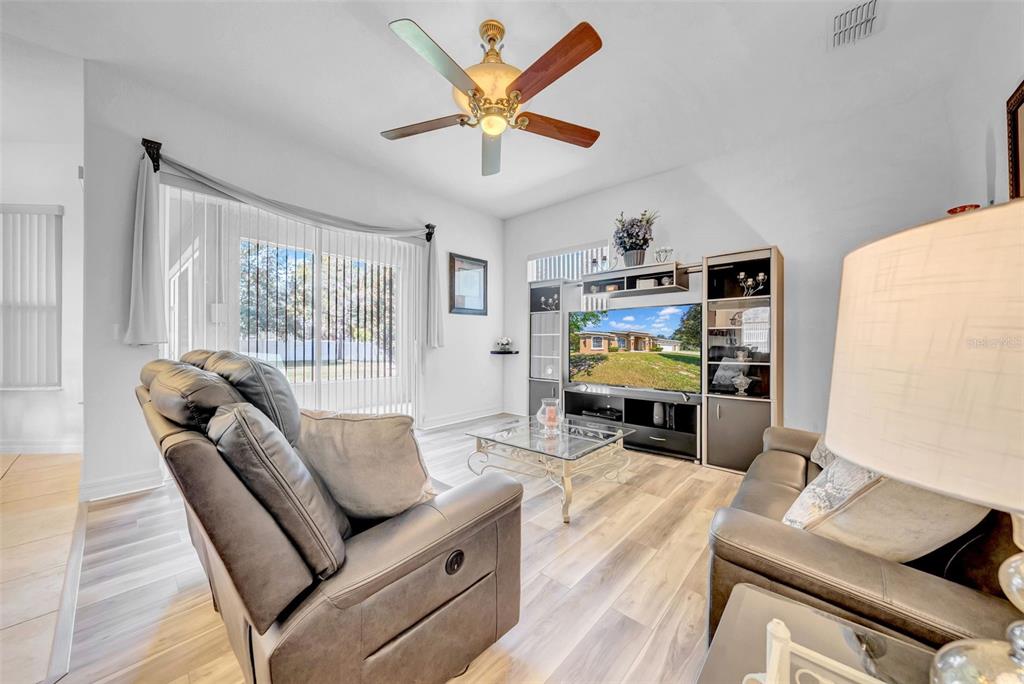 10177 Deer Street Spring Hill, FL 34608 - Photo 30 of 73 a living room with furniture ceiling fan and a wooden floor