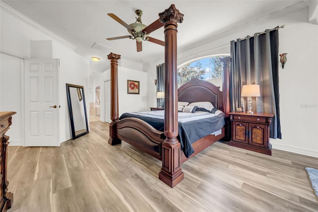 10177 Deer Street Spring Hill, FL 34608 - Photo 34 of 73 a bedroom with a bed lamp closet and large window