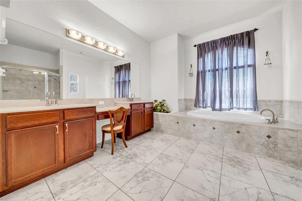 10177 Deer Street Spring Hill, FL 34608 - Photo 38 of 73 a spacious bathroom with a granite countertop sink mirror and bathtub