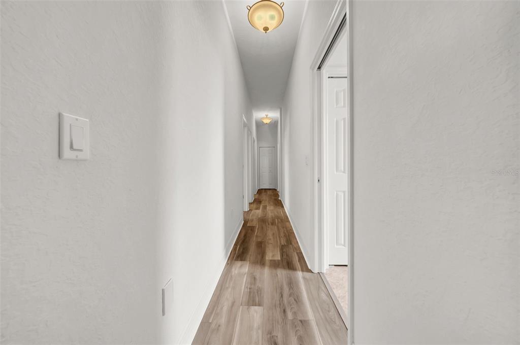 10177 Deer Street Spring Hill, FL 34608 - Photo 42 of 73 a view of a hallway with wooden floor and glass door