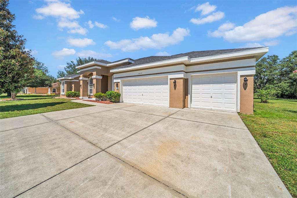 10177 Deer Street Spring Hill, FL 34608 - Photo 9 of 73 a front view of a house with a yard and garage