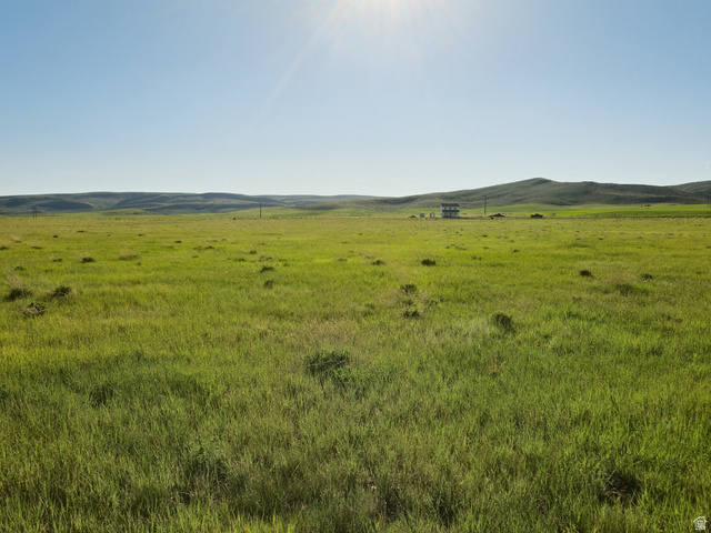 1844 Lower Bern Road, Unit 5 Bern, ID 83220 - Photo 3 of 6 Expansive green pastureland with distant rolling hills and a bright, clear sky