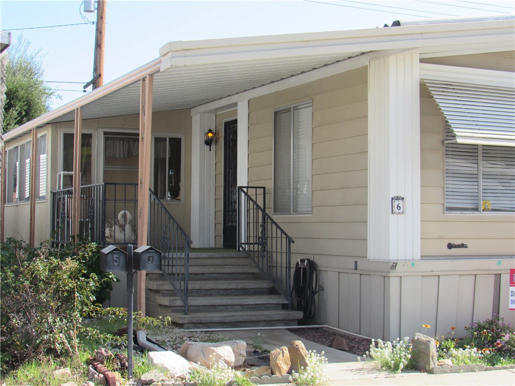 a view of a house with a small yard and wooden floor and fence