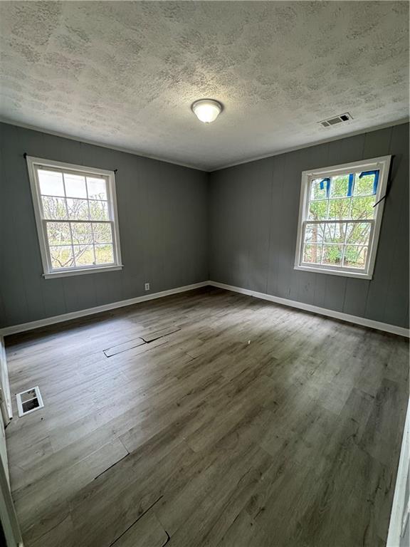 26 Plainview Drive Southwest Cartersville, GA 30120 - Photo 10 of 18 an empty room with wooden floor and windows