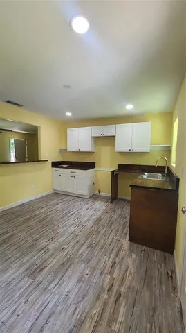 a large kitchen with stainless steel appliances granite countertop a large counter top and a stove with wooden floor