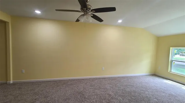 an empty room with a window and a fan