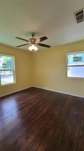 a view of a room with wooden floor and a window