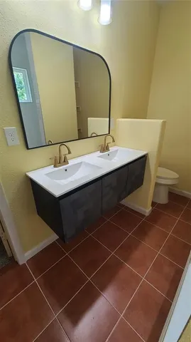 a bathroom with a sink mirror and toilet