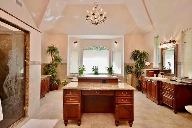 a view of an empty room with window and a kitchen