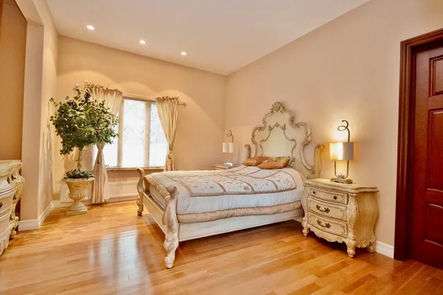 a bedroom with a large bed and a chandelier