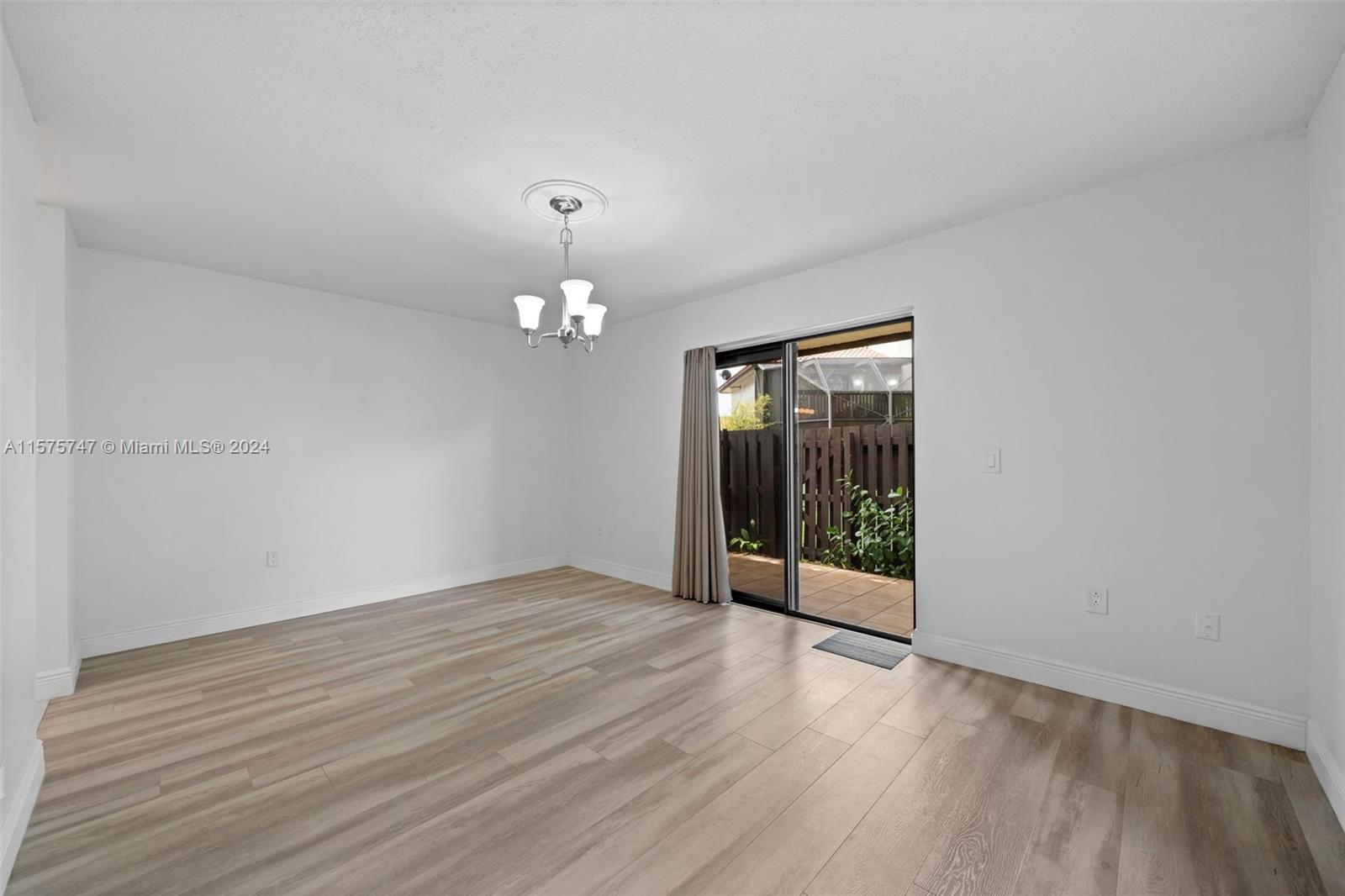 13298 Southwest 112th Terrace, Unit 461 Miami, FL 33186 - Photo 12 of 35 an empty room with wooden floor and mirror