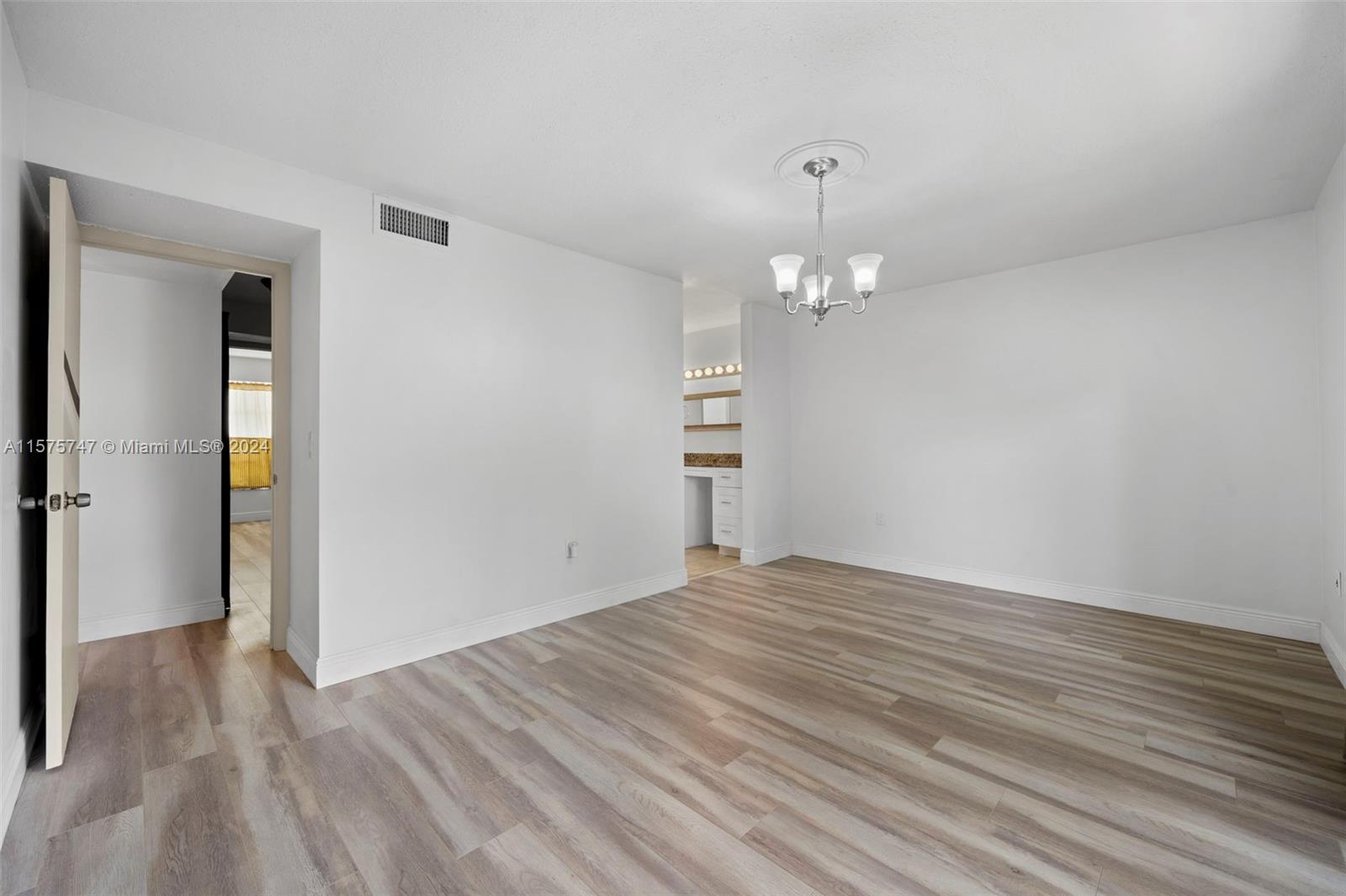 13298 Southwest 112th Terrace, Unit 461 Miami, FL 33186 - Photo 13 of 35 wooden floor in an empty room with a window