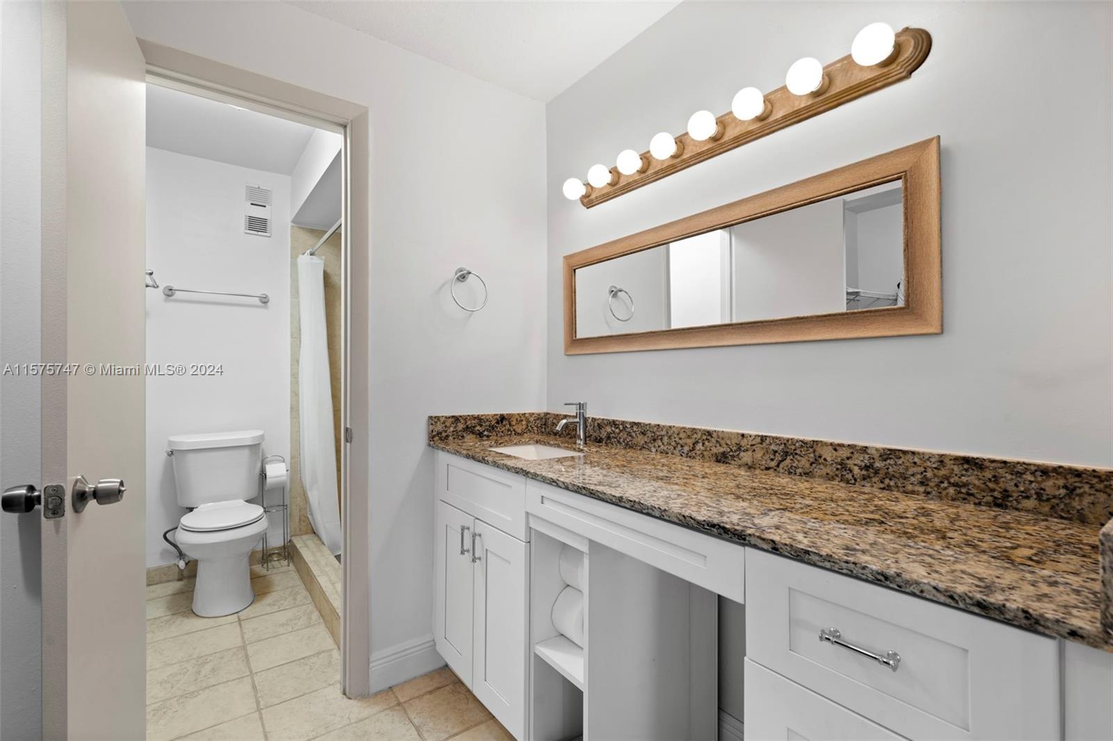 13298 Southwest 112th Terrace, Unit 461 Miami, FL 33186 - Photo 15 of 35 a bathroom with a granite countertop sink a toilet and a mirror
