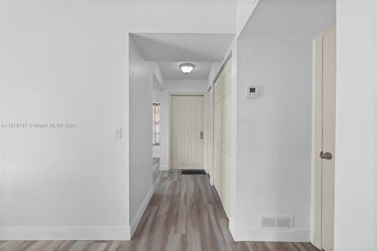 13298 Southwest 112th Terrace, Unit 461 Miami, FL 33186 - Photo 2 of 35 a view of a hallway with wooden floor and a bathroom