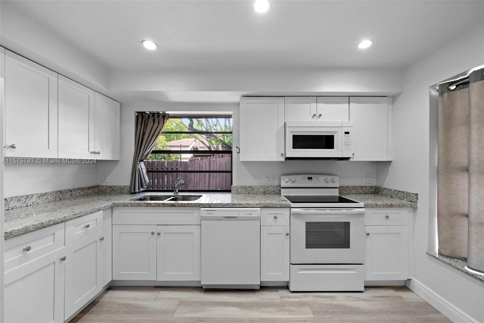 13298 Southwest 112th Terrace, Unit 461 Miami, FL 33186 - Photo 3 of 35 a kitchen with white cabinets stainless steel appliances and sink